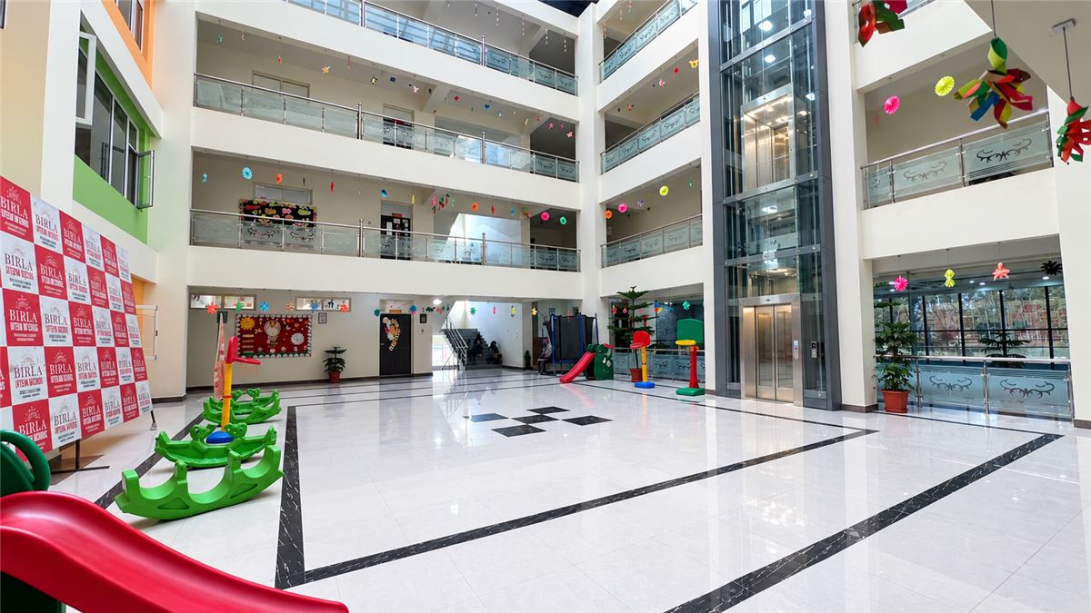 Glass lift serving all five floors of the atrium at Birla Open Minds International School, HMT Srinagar